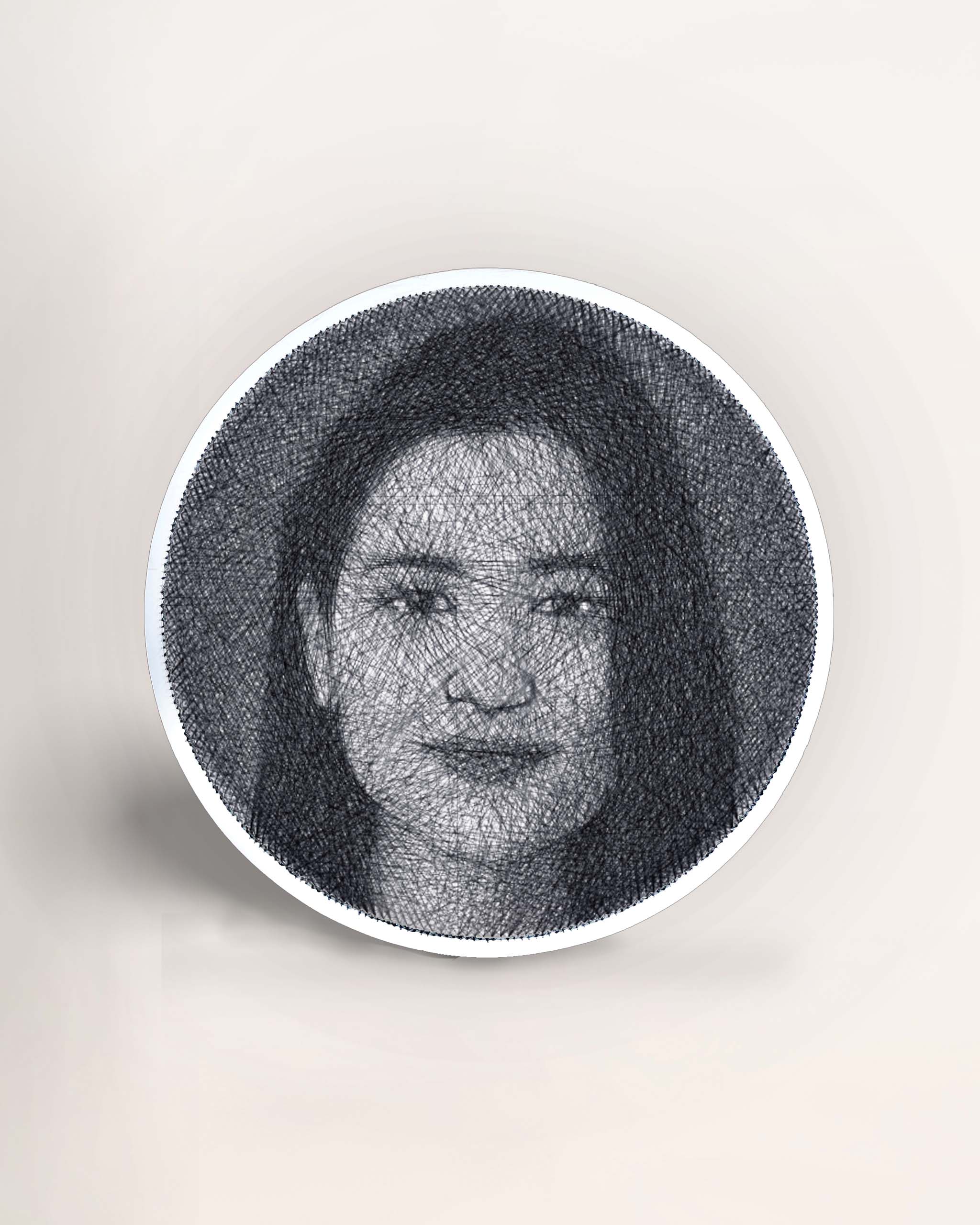 A thread nail art portrait depicting a round-shaped face, crafted with black strings on a brown framed board.